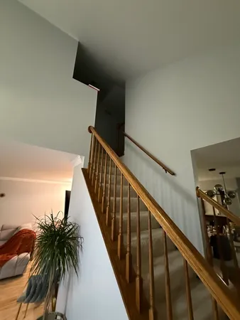 a view of a hallway with wooden floor and stairs