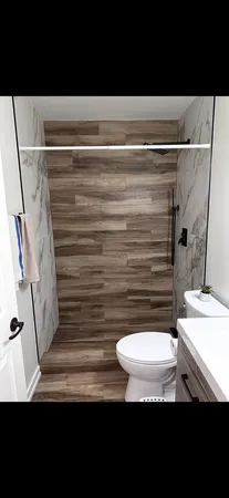 a bathroom with a sink a toilet a mirror and shower