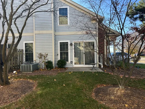 a view of a brick house with a large trees