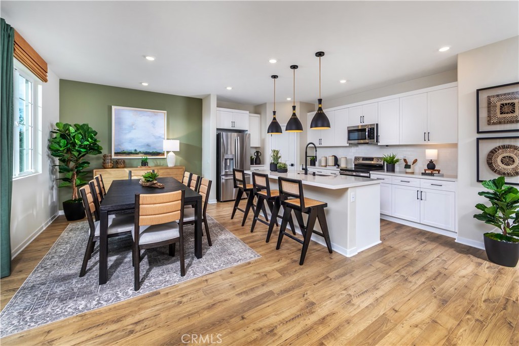 9568 Glenmore Frst Drive Riverside, CA 92508 - Photo 2 of 12 a kitchen with stainless steel appliances kitchen island granite countertop a sink a stove a dining table and chairs