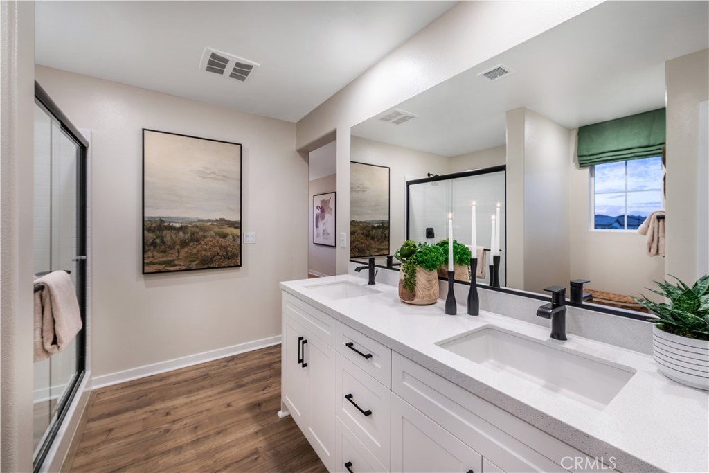 9568 Glenmore Frst Drive Riverside, CA 92508 - Photo 5 of 12 a bathroom with a double vanity sink a mirror and a shower