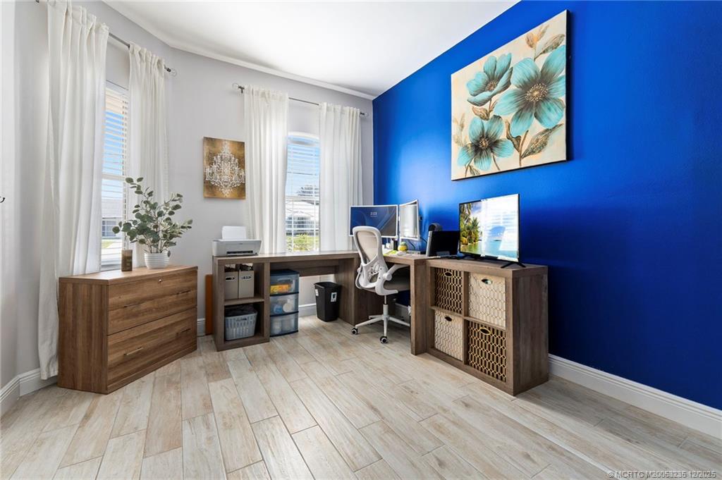 801 Southwest Tulip Boulevard Port St. Lucie, FL 34953 - Photo 13 of 41 a view of a workspace with furniture and wooden floor