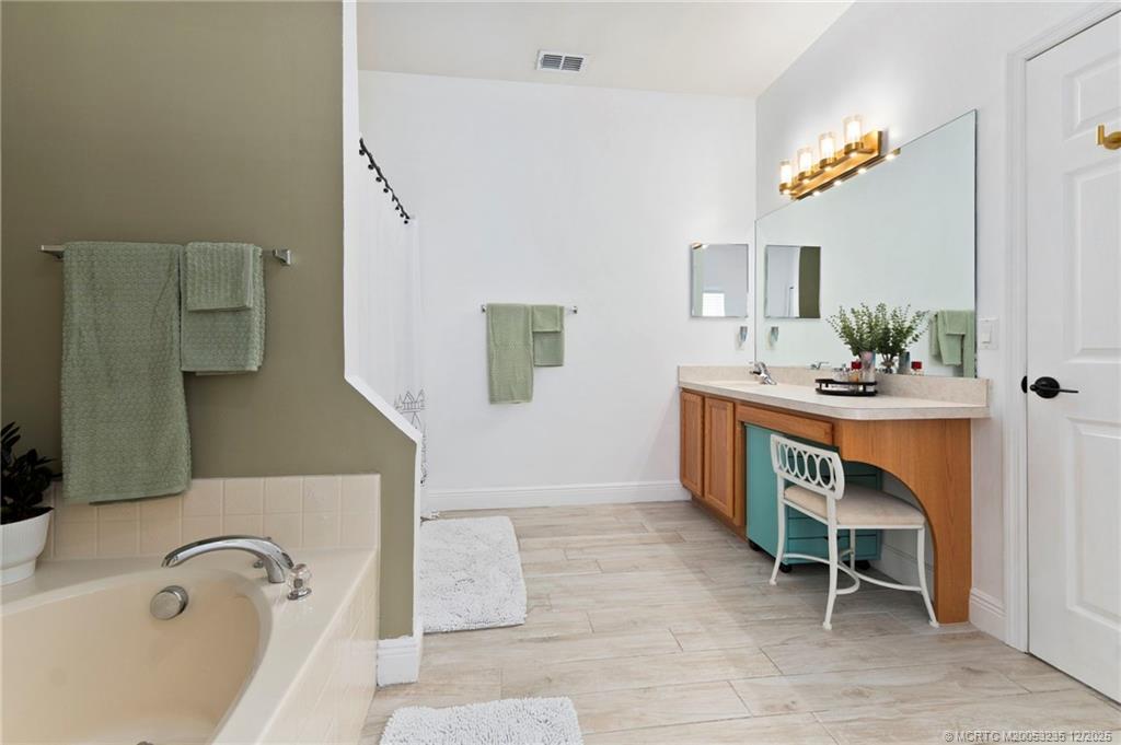 801 Southwest Tulip Boulevard Port St. Lucie, FL 34953 - Photo 28 of 41 a bathroom with a sink a bath tub and a mirror