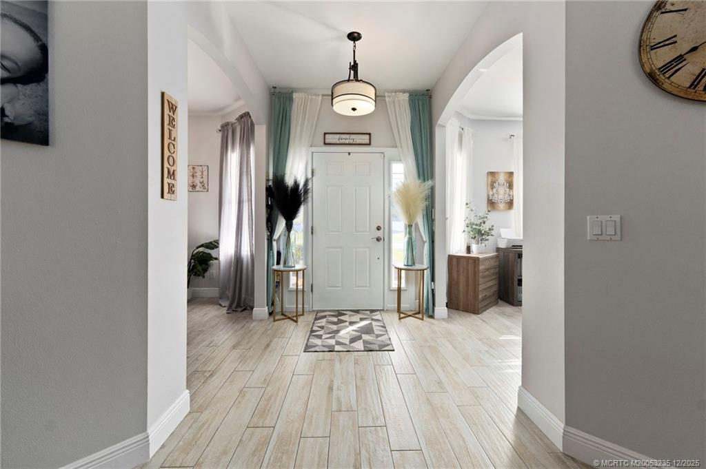 801 Southwest Tulip Boulevard Port St. Lucie, FL 34953 - Photo 8 of 41 a view of a hallway with wooden floor and a living room