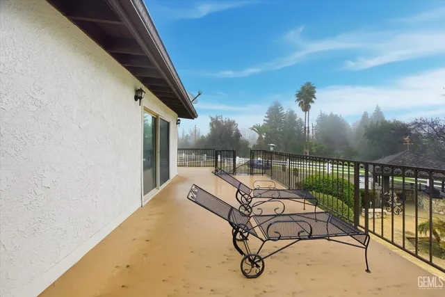 a view of a swimming pool with a yard and palm trees