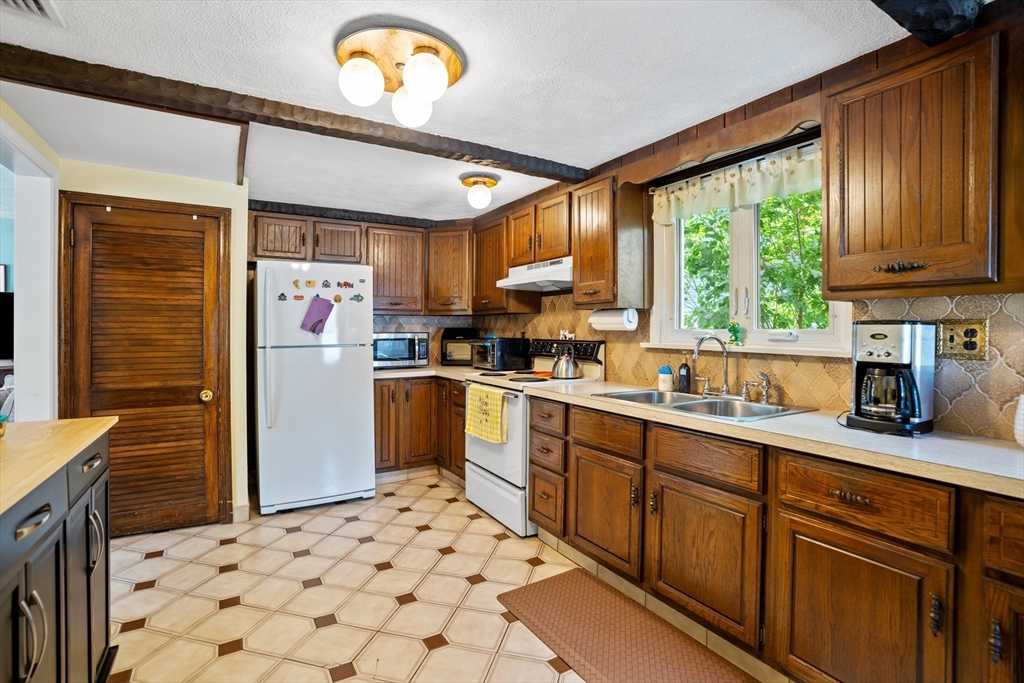 19 Belcher Street Winthrop, MA 02152 - Photo 15 of 33 a kitchen with granite countertop a refrigerator and a sink