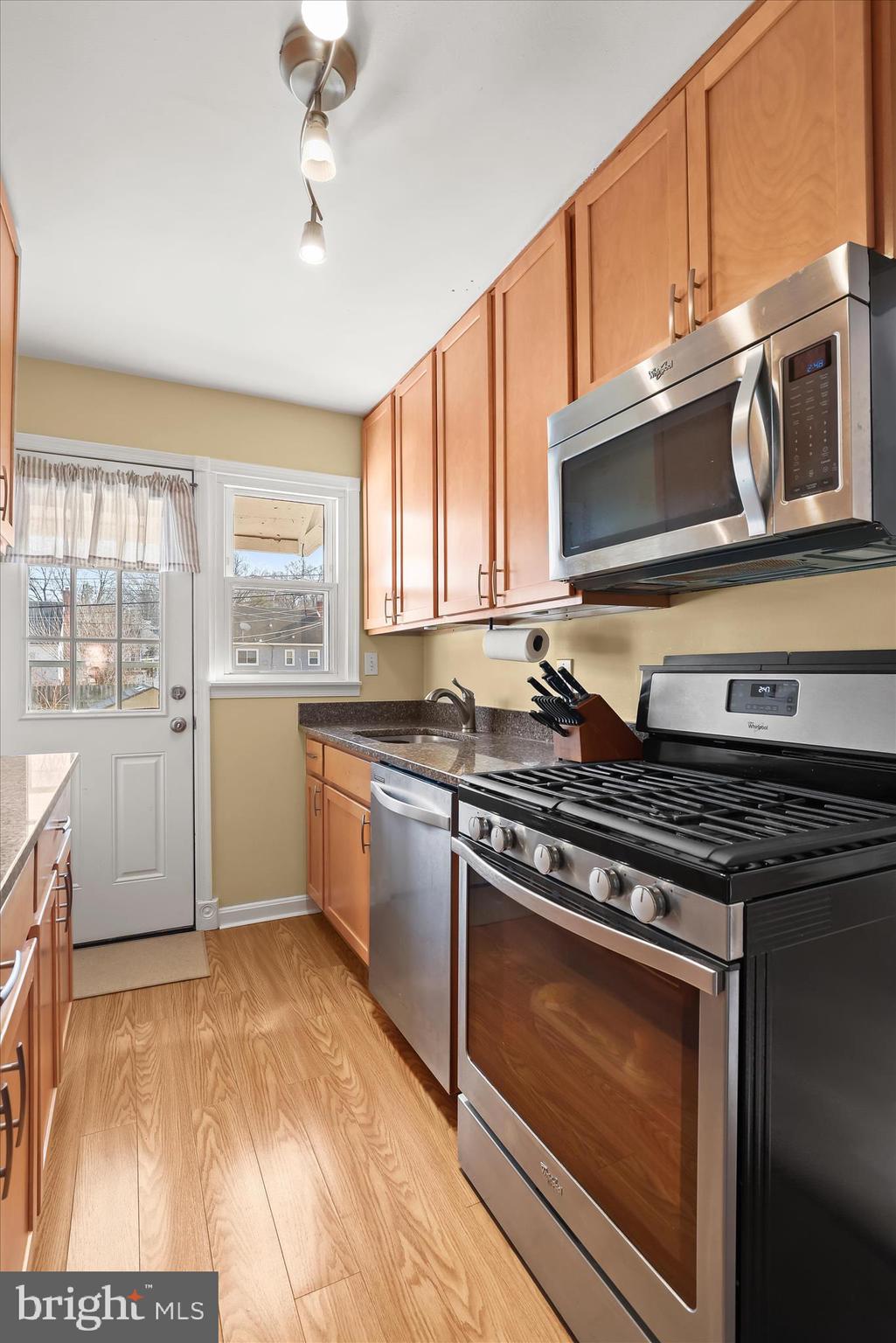 1207 Brewster Street Halethorpe, MD 21227 - Photo 13 of 34 a kitchen with stainless steel appliances granite countertop a stove a sink and a microwave