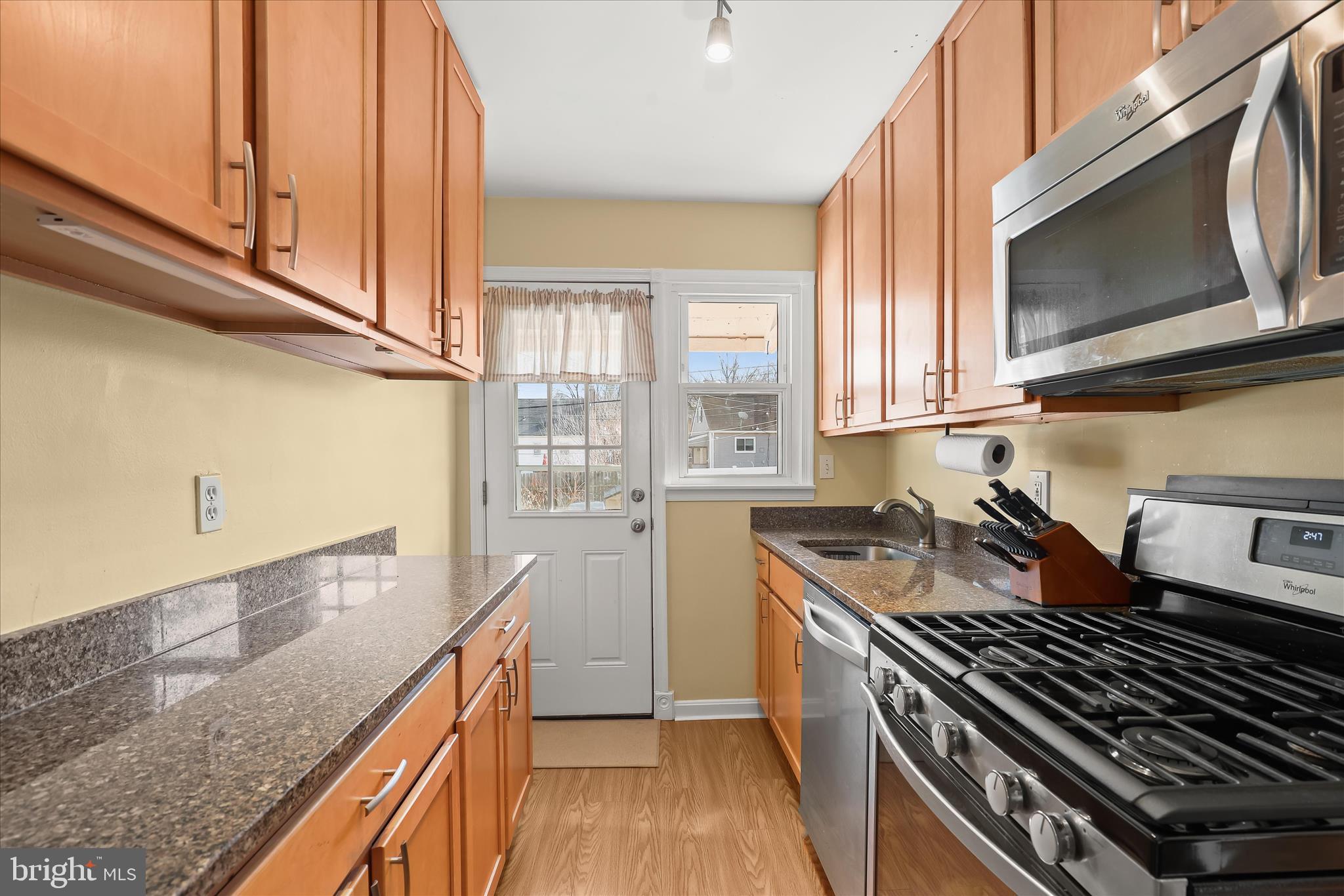 1207 Brewster Street Halethorpe, MD 21227 - Photo 14 of 34 a kitchen with granite countertop a stove sink and microwave
