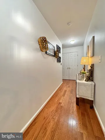 a bedroom with a bed and dresser with wooden floor
