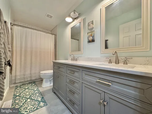 a view of a hallway with toilet and sink