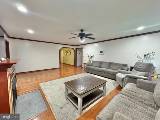 a living room with a couch and a dining table with wooden floor