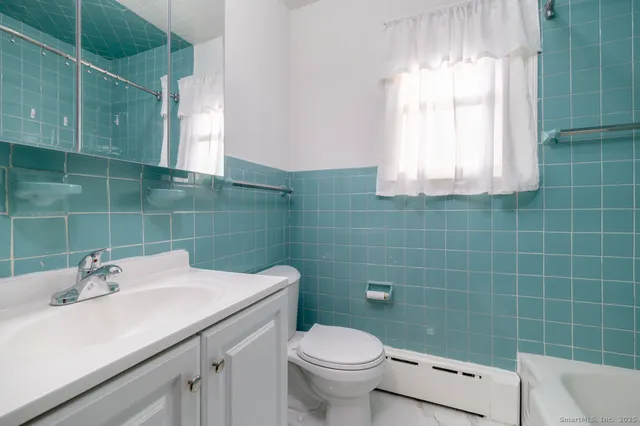 a bathroom with a sink a toilet and a mirror