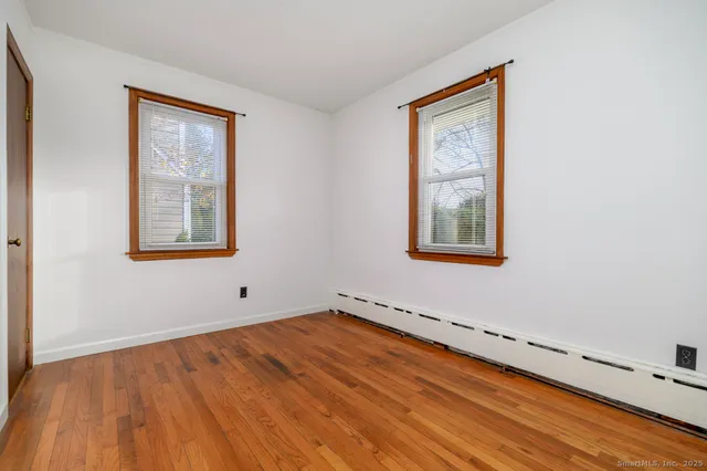 a view of a room with wooden floor and window