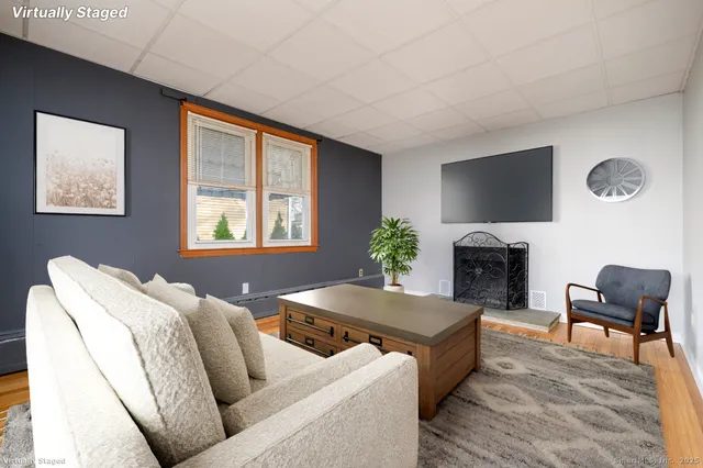 a living room with furniture a wooden floor and next to a window