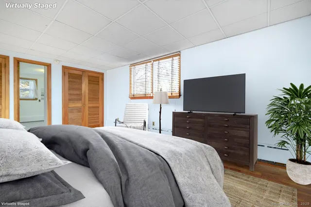 a bedroom with furniture and a flat screen tv