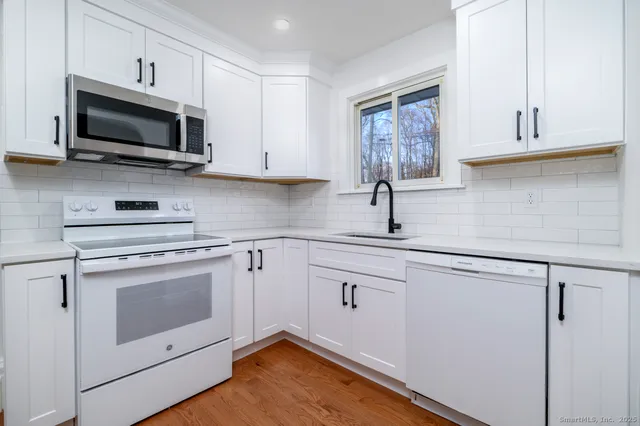 a kitchen with white cabinets stainless steel appliances and sink