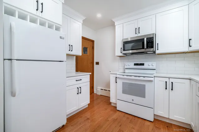 a kitchen with white cabinets and stainless steel appliances