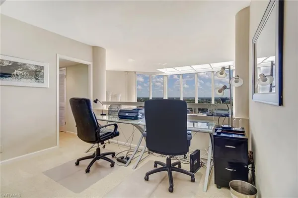 a spacious bedroom with a bed and a flat tv screen on dresser