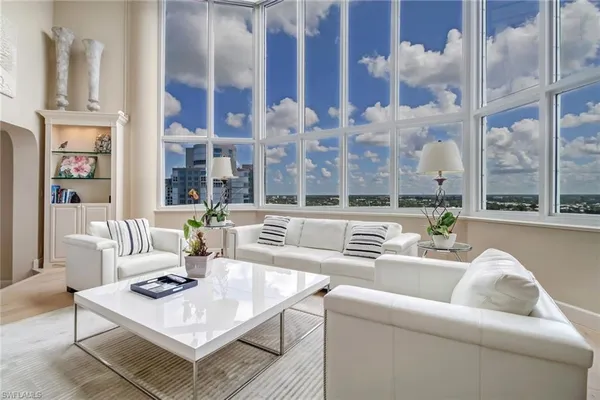 a living room with fireplace furniture and a large window