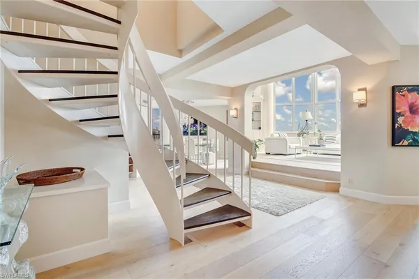 a kitchen with stainless steel appliances granite countertop a refrigerator a sink dishwasher a stove and a refrigerator with wooden floor