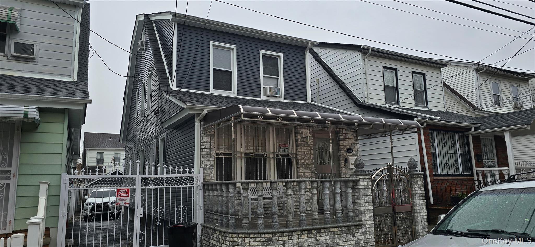 View of front of property with stone siding and a gate