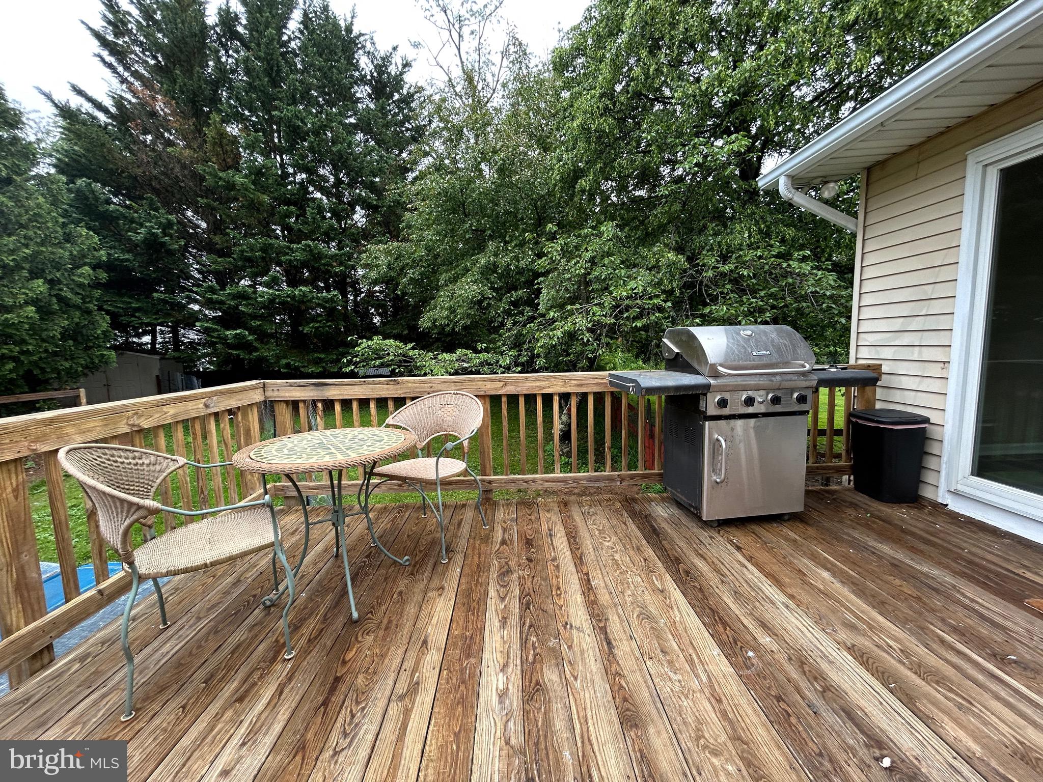 3825 Salem Bottom Road Westminster, MD 21157 - Photo 33 of 43 a view of a roof deck with table and chairs a barbeque with wooden floor and fence
