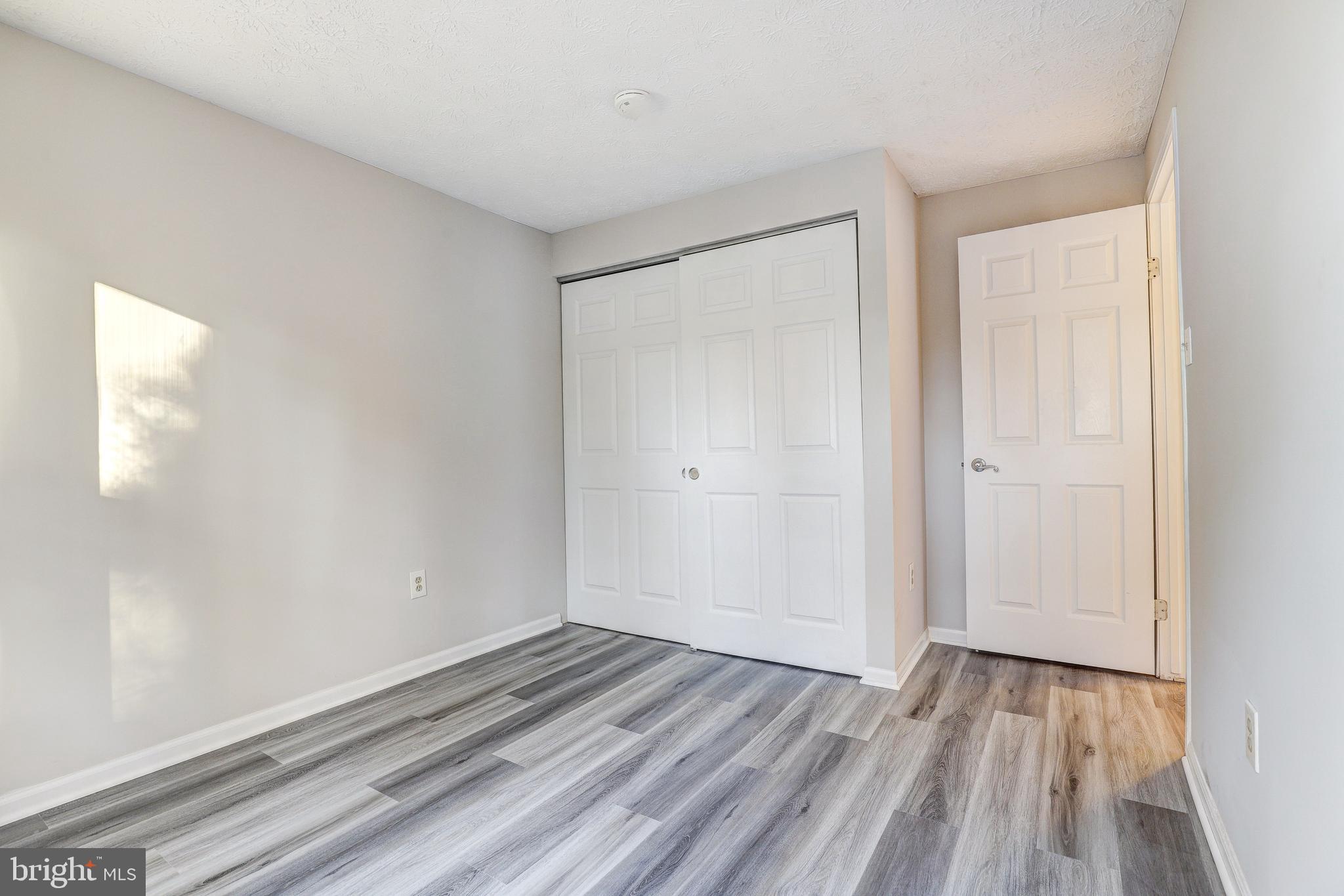 5920 Watch Chain Way, Unit 5106 Columbia, MD 21044 - Photo 13 of 27 a view of an empty room with wooden floor and a window