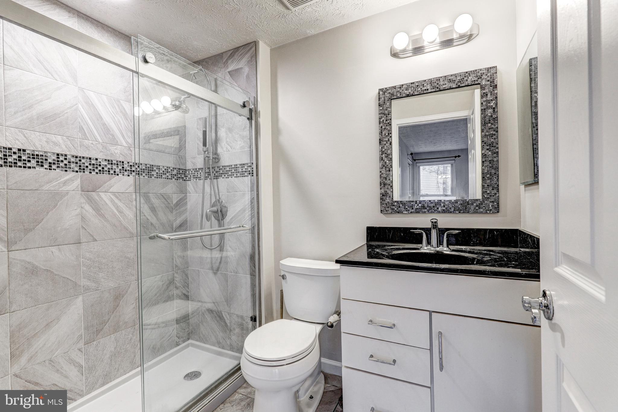 5920 Watch Chain Way, Unit 5106 Columbia, MD 21044 - Photo 18 of 27 a bathroom with a granite countertop sink a toilet and a mirror
