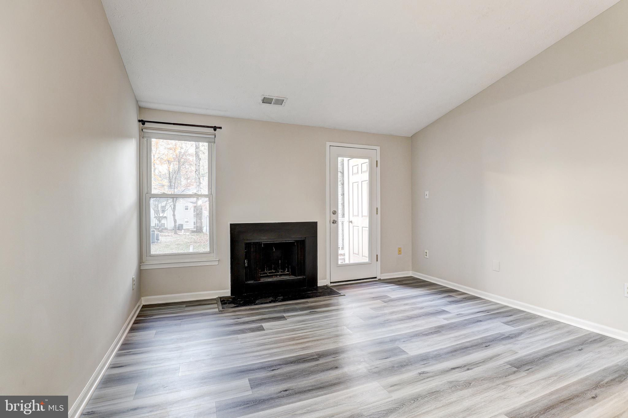 5920 Watch Chain Way, Unit 5106 Columbia, MD 21044 - Photo 2 of 27 an empty room with wooden floor fireplace and windows