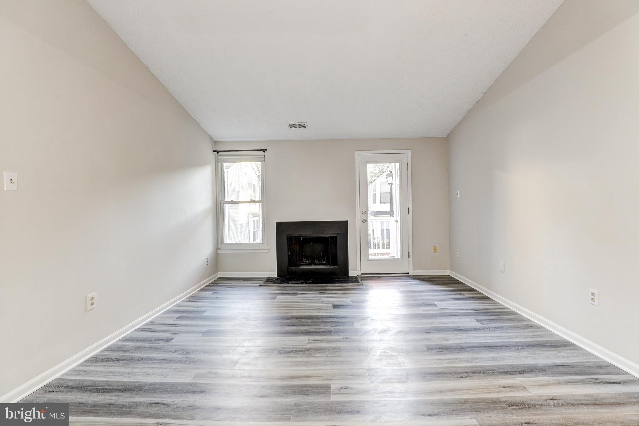 5920 Watch Chain Way, Unit 5106 Columbia, MD 21044 - Photo 3 of 27 a view of an empty room with wooden floor fireplace and a window
