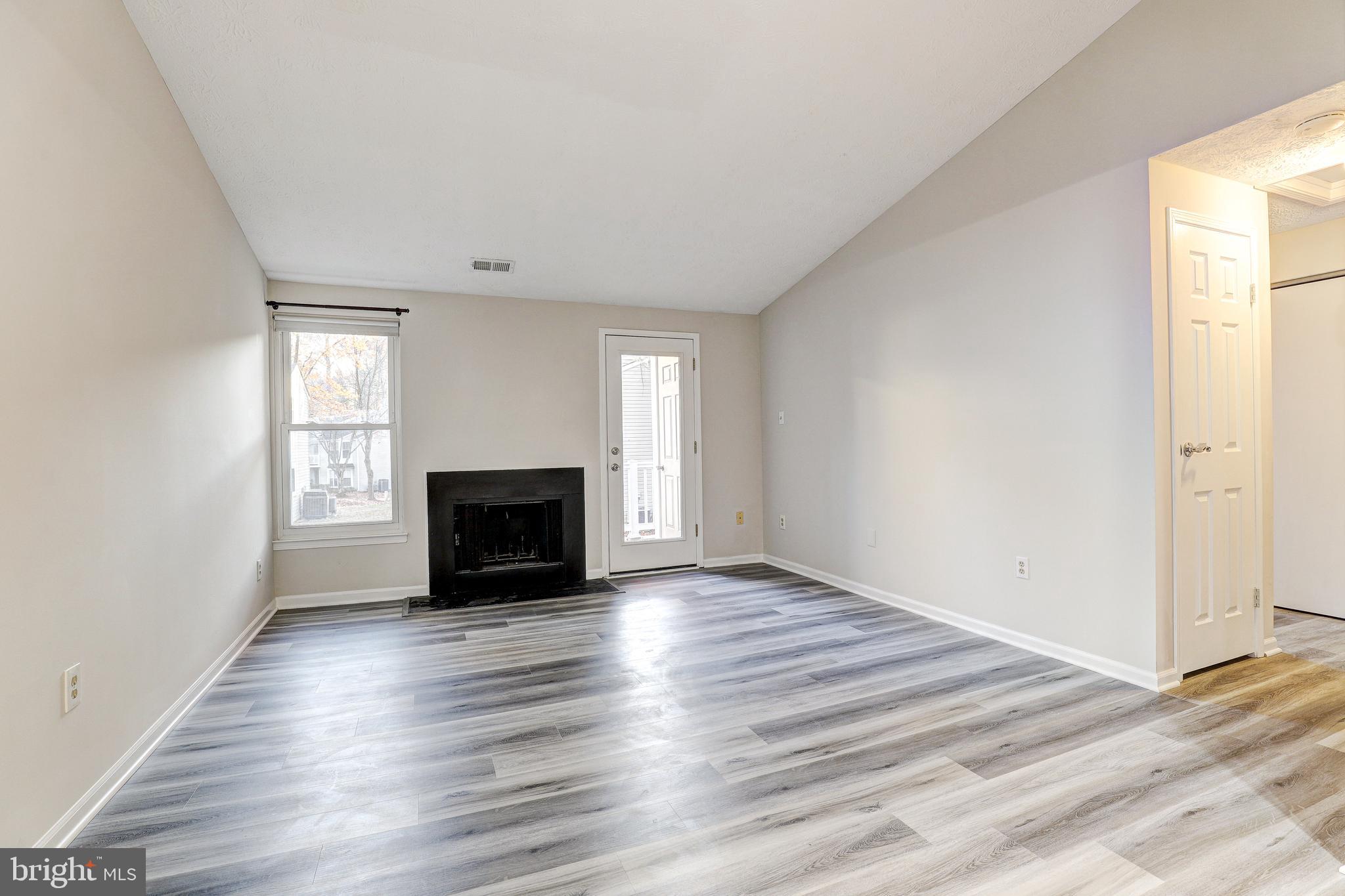 5920 Watch Chain Way, Unit 5106 Columbia, MD 21044 - Photo 4 of 27 an empty room with wooden floor a fireplace and windows