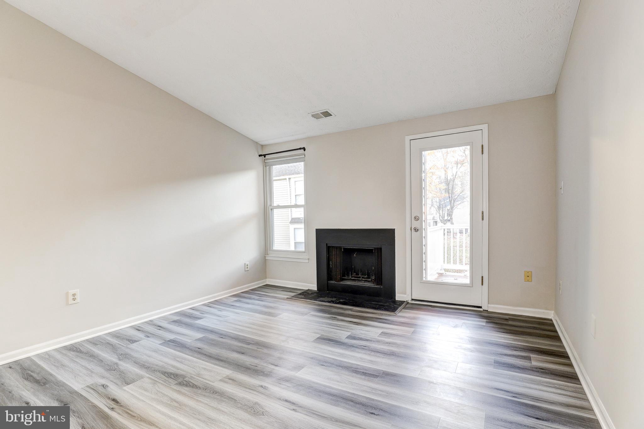 5920 Watch Chain Way, Unit 5106 Columbia, MD 21044 - Photo 5 of 27 a view of empty room with wooden floor and fireplace