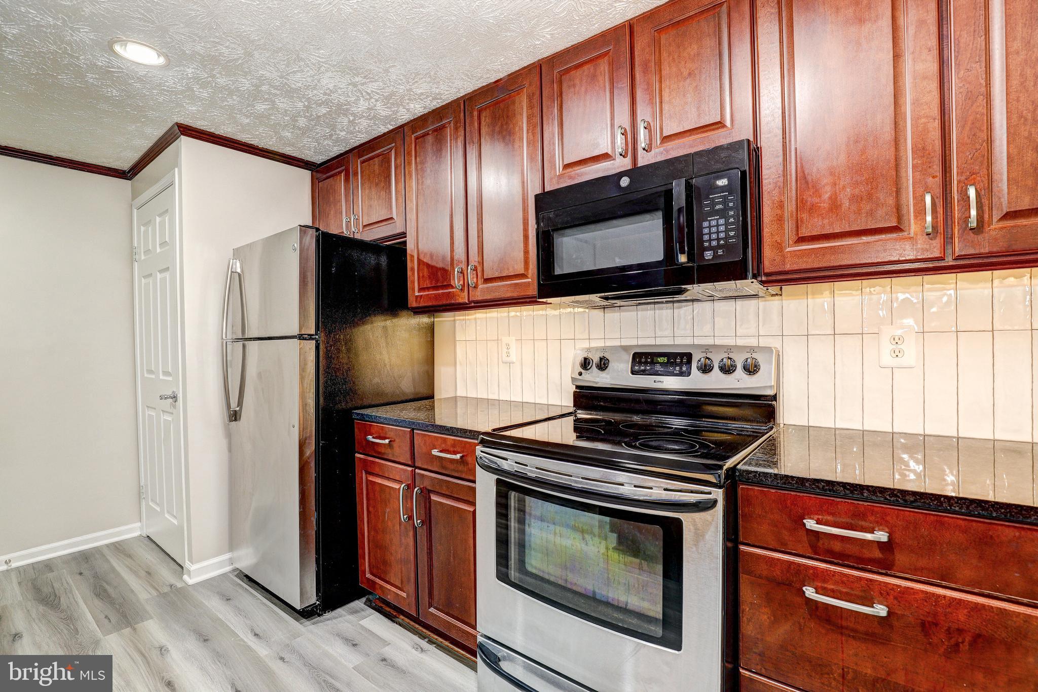 5920 Watch Chain Way, Unit 5106 Columbia, MD 21044 - Photo 6 of 27 a kitchen with stainless steel appliances granite countertop a stove microwave and refrigerator