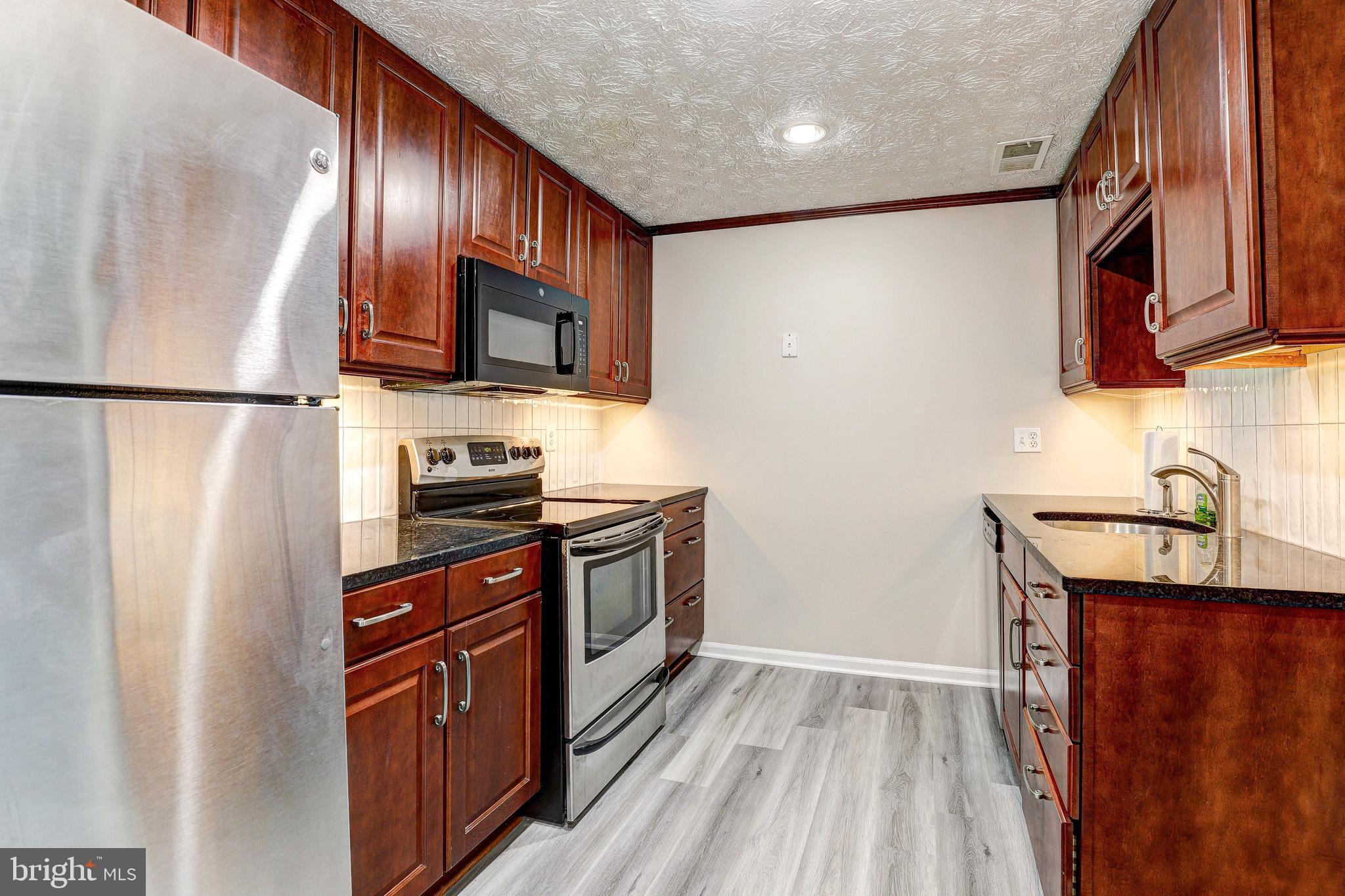5920 Watch Chain Way, Unit 5106 Columbia, MD 21044 - Photo 7 of 27 a kitchen with stainless steel appliances granite countertop a refrigerator stove and sink