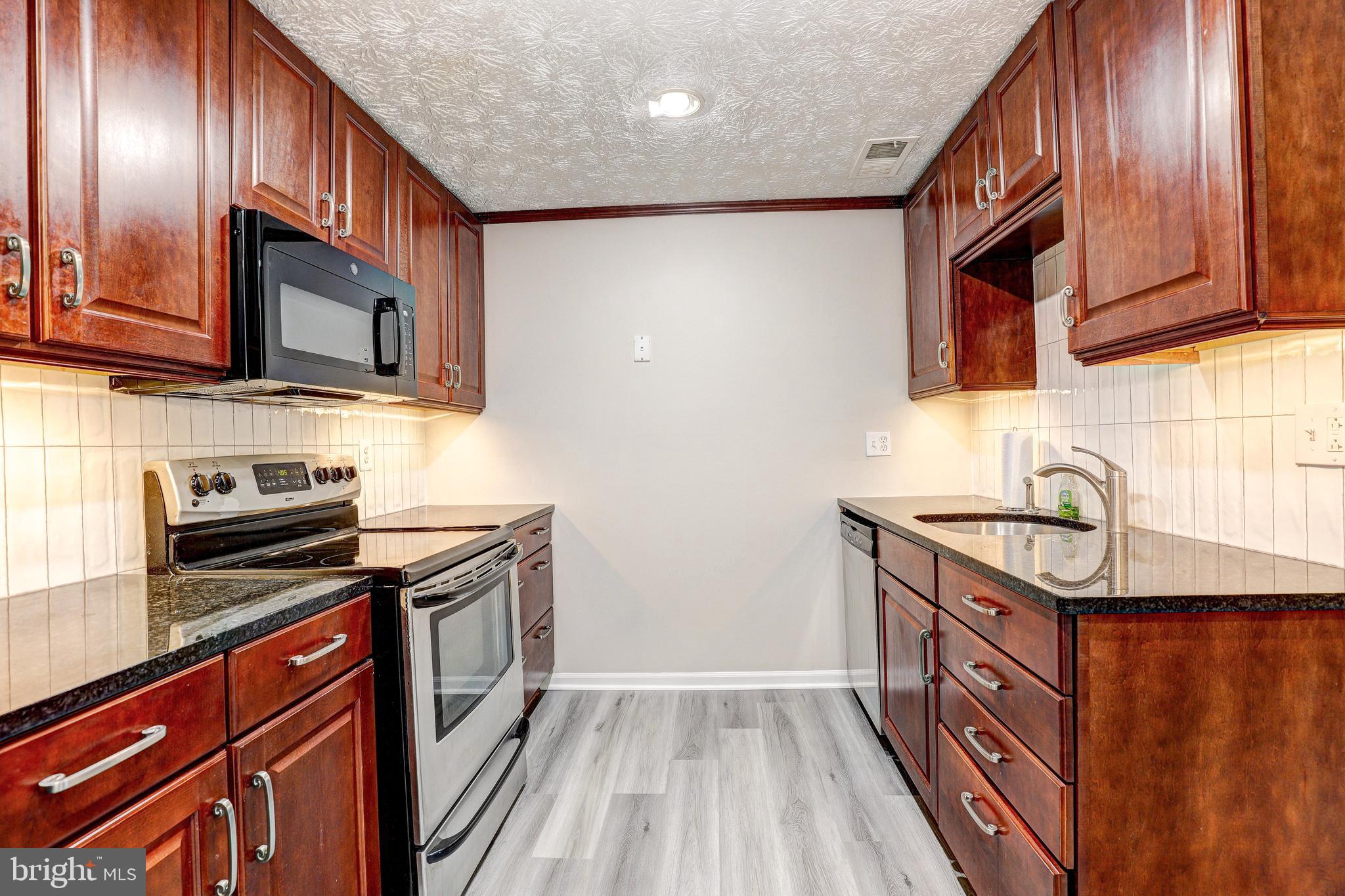 5920 Watch Chain Way, Unit 5106 Columbia, MD 21044 - Photo 9 of 27 a kitchen with granite countertop stainless steel appliances and wooden cabinets