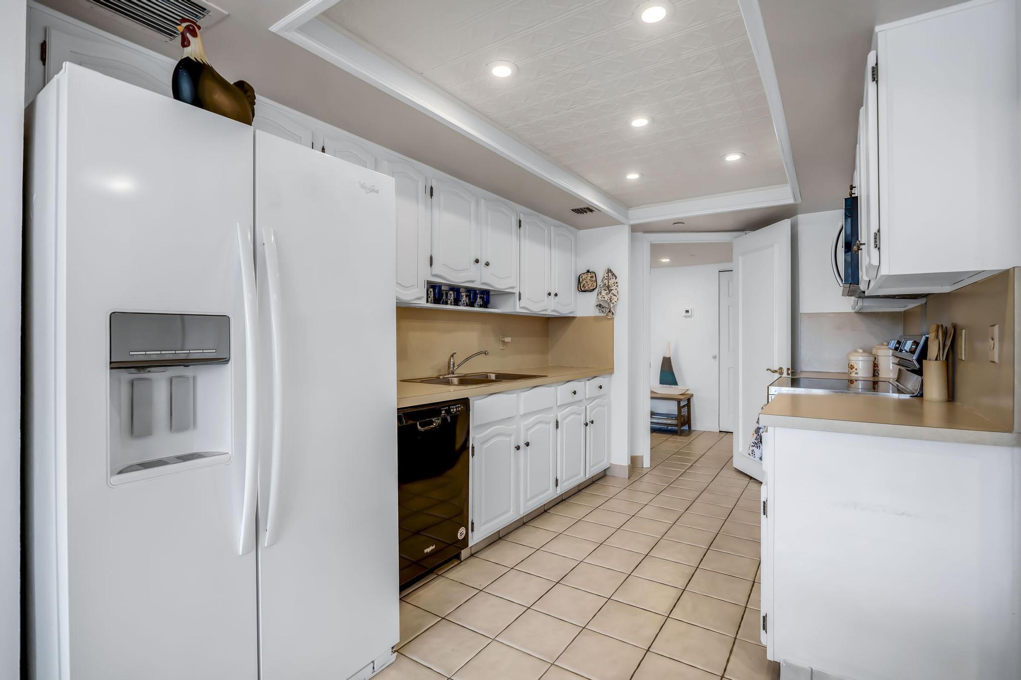 4301 North Ocean Boulevard, Unit A206 Boca Raton, FL 33431 - Photo 16 of 65 a kitchen with stainless steel appliances a refrigerator sink and cabinets