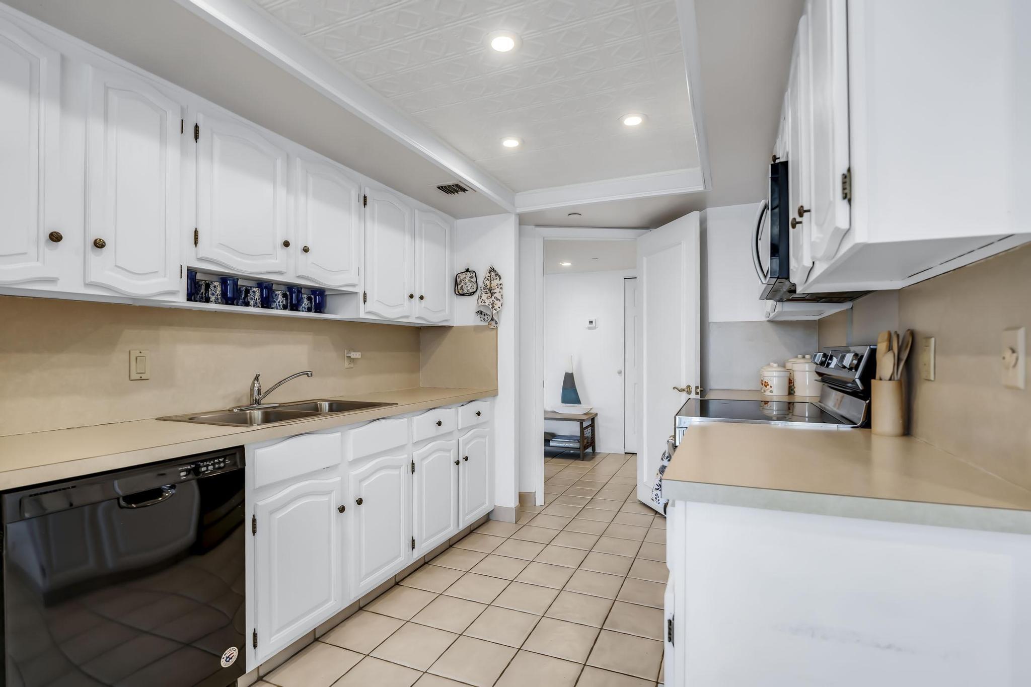 4301 North Ocean Boulevard, Unit A206 Boca Raton, FL 33431 - Photo 17 of 65 a kitchen with granite countertop a sink a stove and cabinets