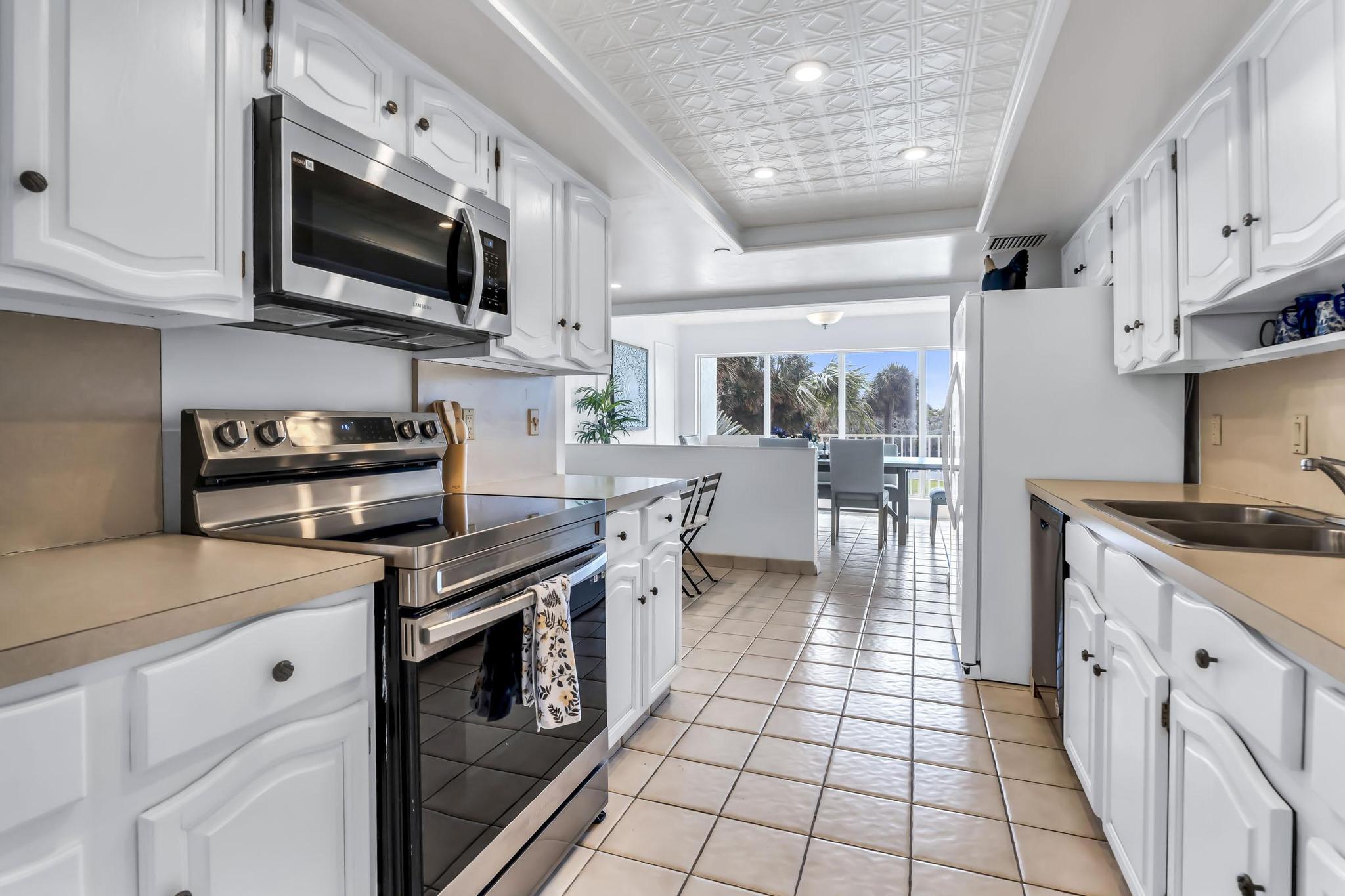 4301 North Ocean Boulevard, Unit A206 Boca Raton, FL 33431 - Photo 18 of 65 a kitchen with stainless steel appliances granite countertop a stove a sink and a microwave