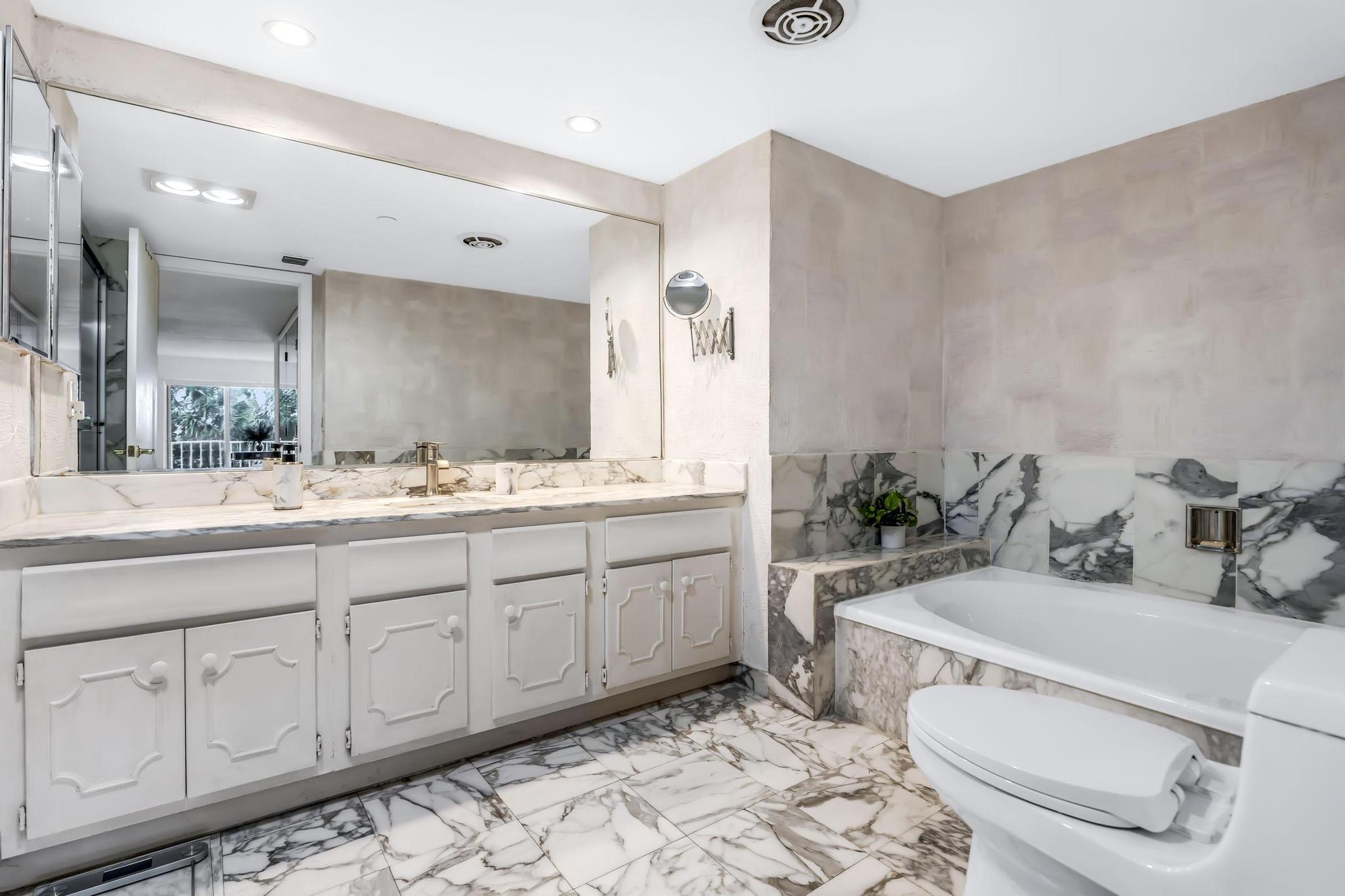 4301 North Ocean Boulevard, Unit A206 Boca Raton, FL 33431 - Photo 25 of 65 a bathroom with a granite countertop sink mirror and toilet