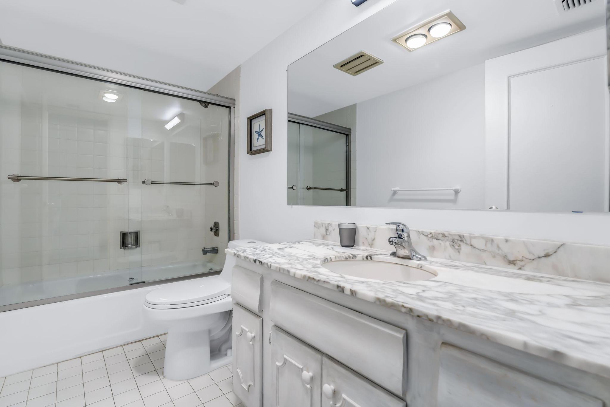4301 North Ocean Boulevard, Unit A206 Boca Raton, FL 33431 - Photo 34 of 65 a bathroom with a granite countertop sink a toilet and shower