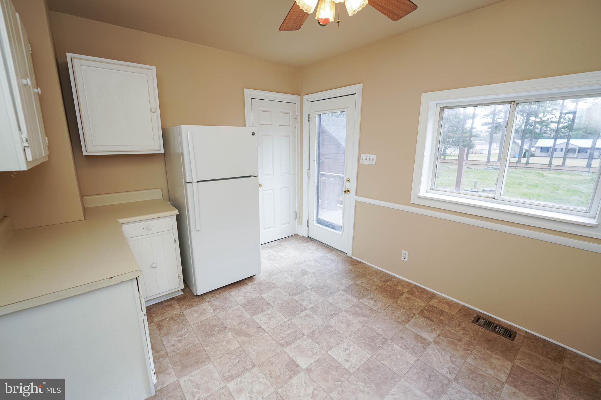 31339 Old Ocean City Road Salisbury, MD 21804 - Photo 20 of 52 a view of a kitchen with a refrigerator cabinets a ceiling fan and a refrigerator