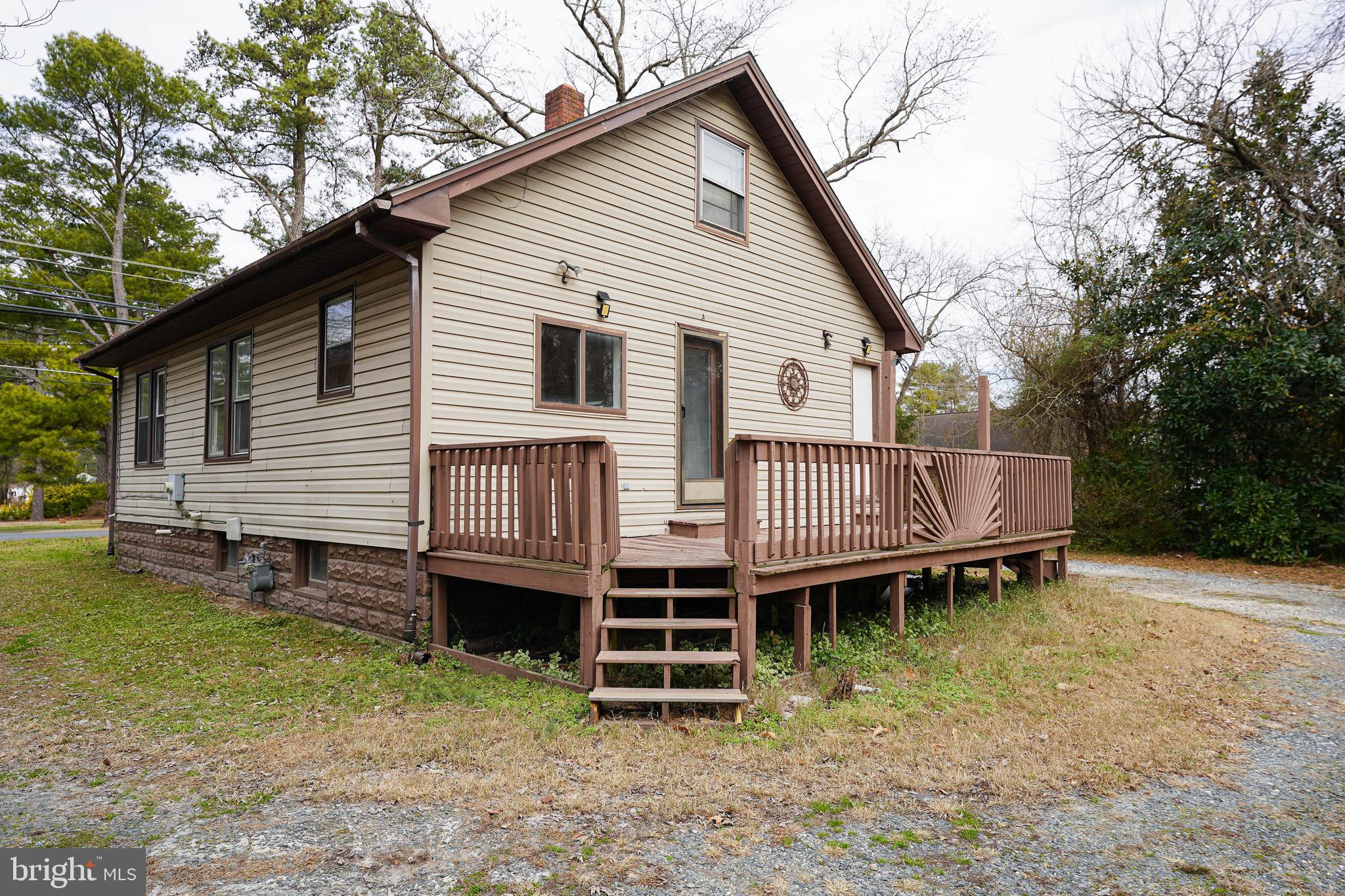 31339 Old Ocean City Road Salisbury, MD 21804 - Photo 6 of 52 a small house with a wooden deck and a yard
