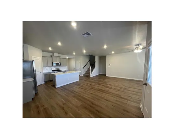 a open hall with kitchen island sink and refrigerator