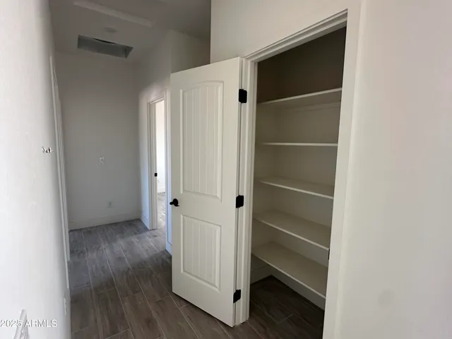an empty room with wooden floor ceiling fan and windows