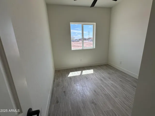 an empty room with wooden floor and a window