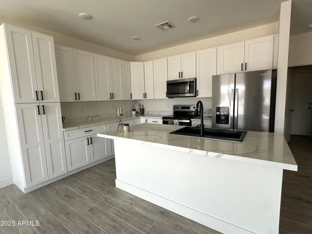 a kitchen with stainless steel appliances granite countertop a sink stove and white cabinets