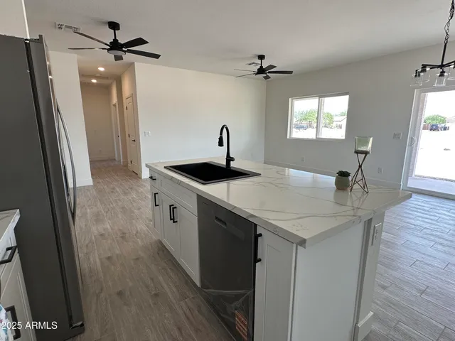 a kitchen with stainless steel appliances granite countertop a sink a microwave a refrigerator and island