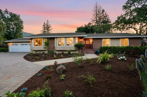 a view of a house with backyard and sitting area