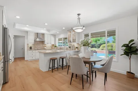 a kitchen with a dining table chairs and refrigerator