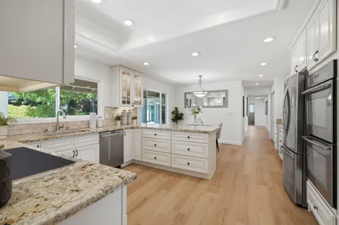 a kitchen with stainless steel appliances kitchen island granite countertop a refrigerator sink and cabinets